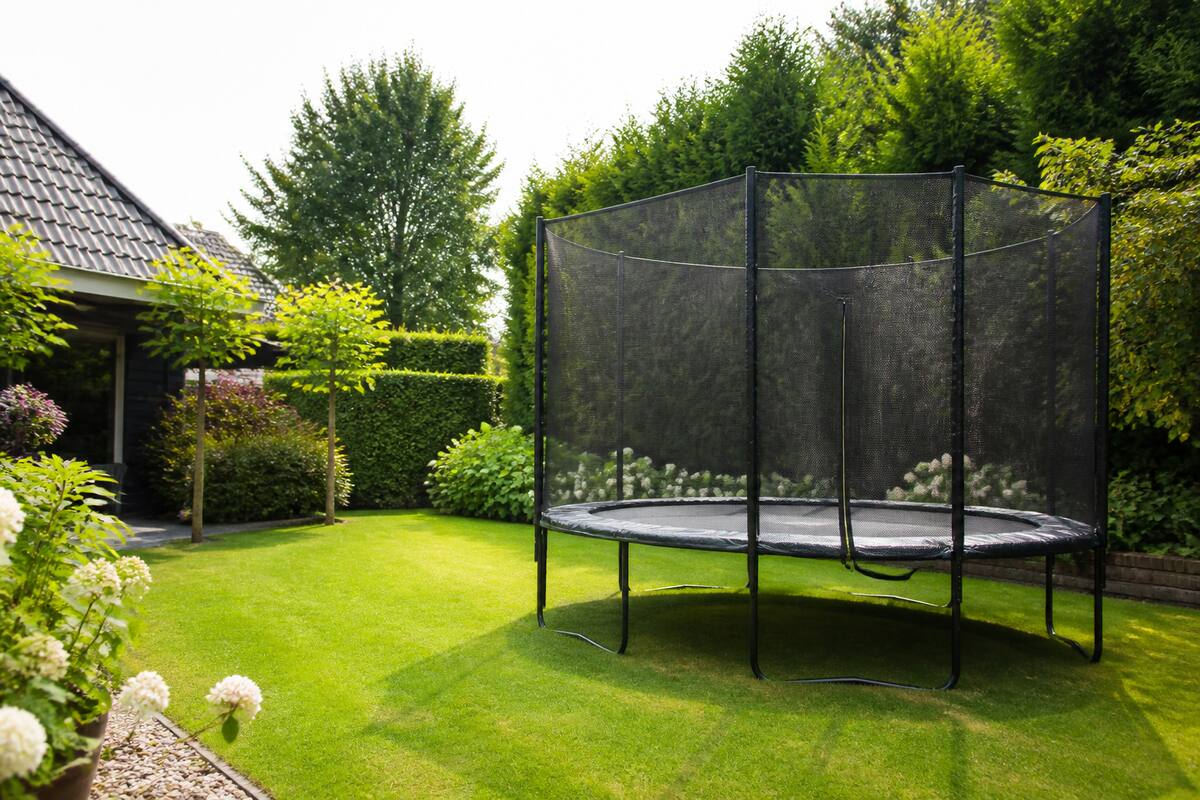 Trampoline met veiligheidsnet in een ruime achtertuin