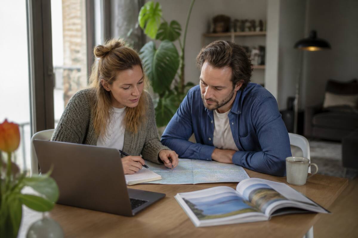 Stel dat vakanties vergelijkt op laptop met notities aan een tafel bij daglicht