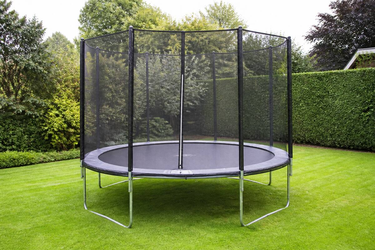 Trampoline in een tuin met veiligheidsnet en randkussen, geschikt als voorbeeld voor beginners bij het kiezen en plaatsen.